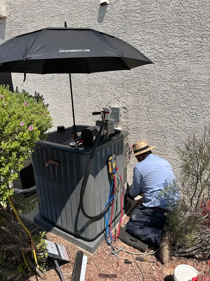 HVAC technician performing outdoor AC maintenance in Sheridan