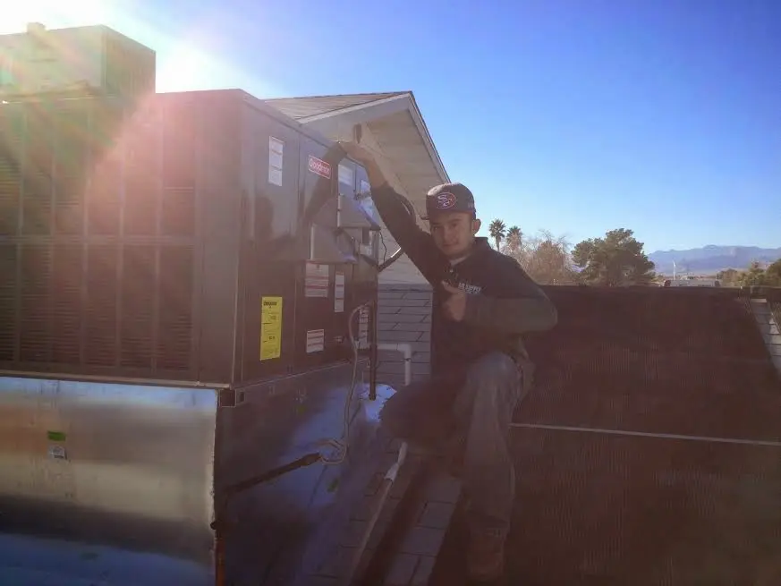 HVAC technician performing Boiler Repair on a rooftop unit in Sheridan